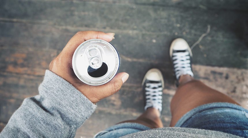 downward-facing shot of Black adolescent girl holding a can of soda