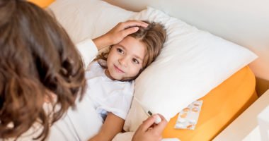 Mother taking care of her sick daughter in bedroom
