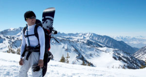 Man hiking to the top of Wasatch Crest and backcountry snowboarding down.