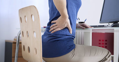 Woman with sore back from sitting too long