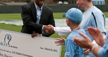 Pediatric neurosurgeon Dr. Victor Perry shakes hands with Glen Kinlaw and his son