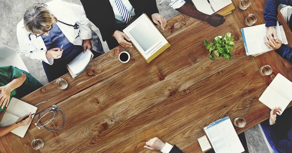 Doctors gathered around a conference table to discuss complex cancer/tumor cases.