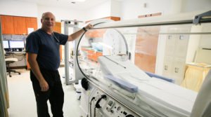 Technician Mike Eastman next to the hyperbaric oxygen chamber