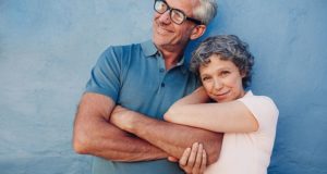 older couple leaning against a wall