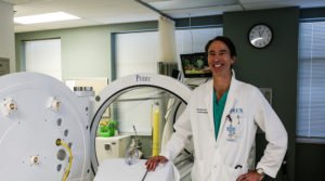 Dr. Sturdivant next to a hyperbaric oxygen chamber