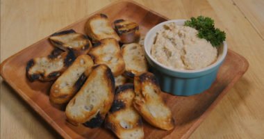 Grilled veggie dip arranged on a plate with grilled bread