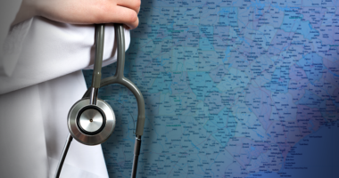 Mid-shot of a doctor holding a stethoscope with a map in the background