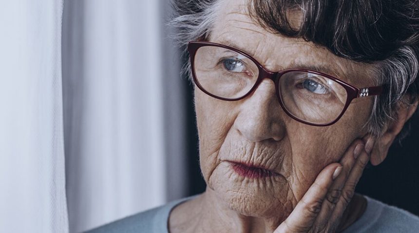Senior woman looking pensively out window