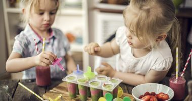 Two Little Girls Preparing Popsicles from a Smoothie