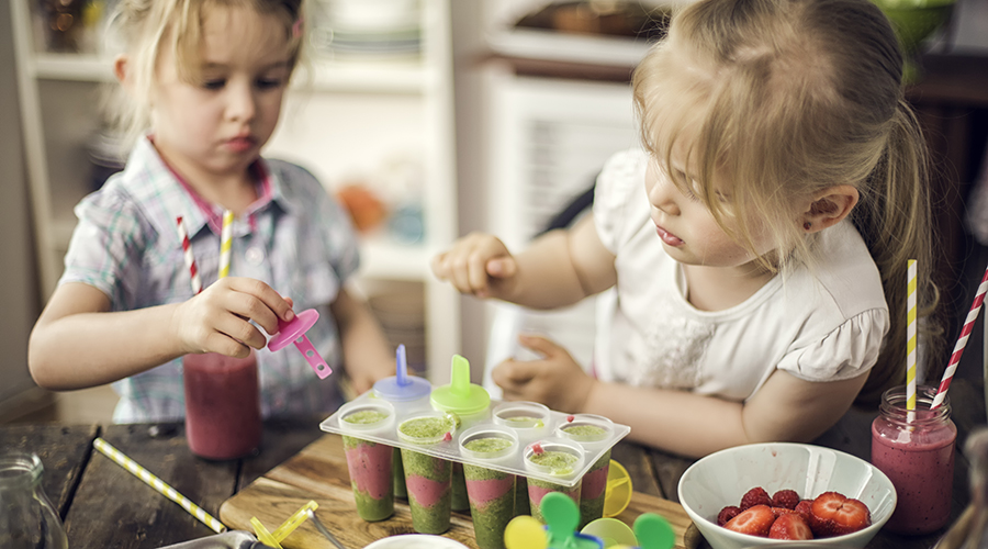 Two Little Girls Preparing Popsicles from a Smoothie