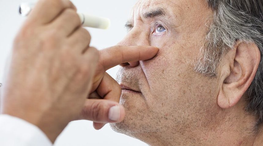 older man having vision examined by doctor