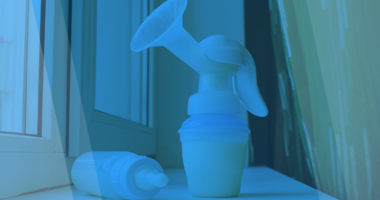 Blue filtered photo of a breast pump and milk bottle