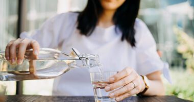 close-up of a woman pouring a glass of water