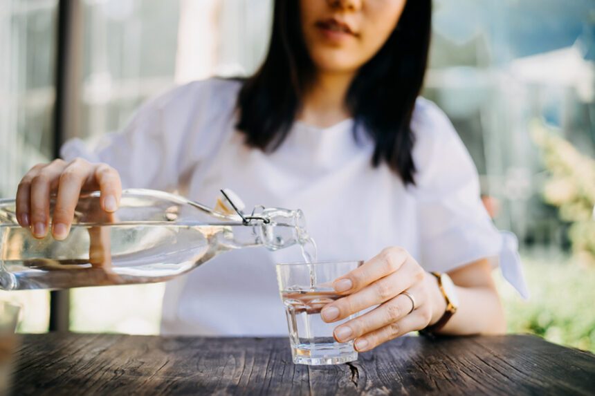 close-up of a woman pouring a glass of water
