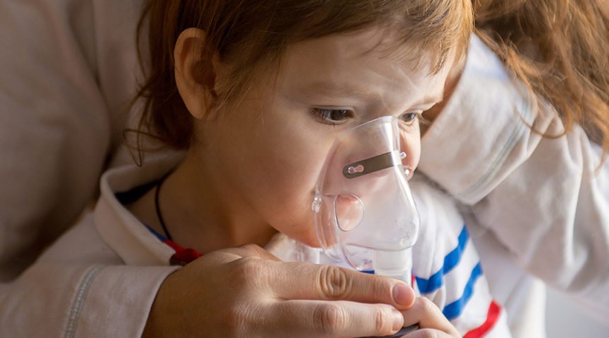 A photograph of a child using a breathing apparatus.