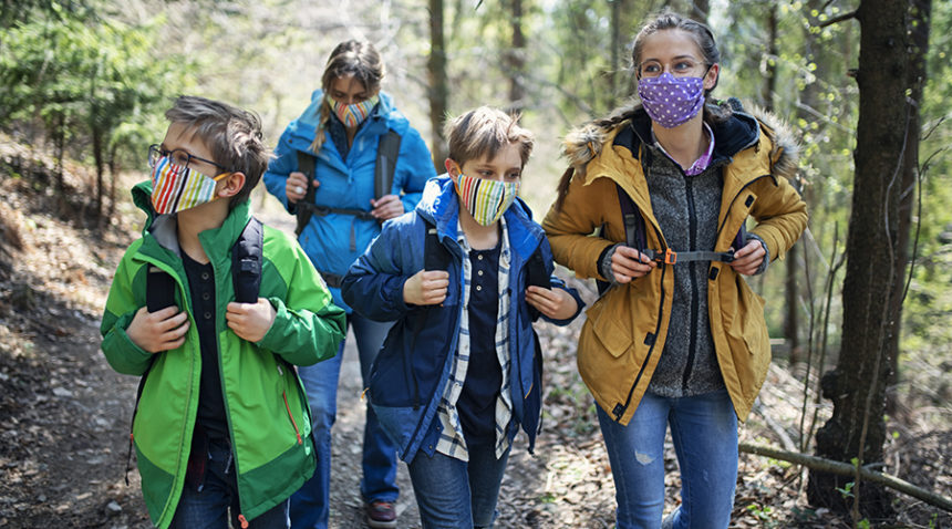 Family on a hike, all wearing face masks