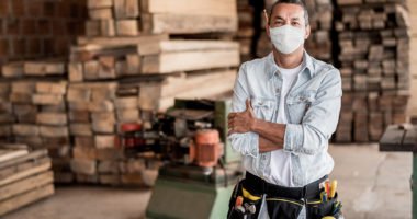 man in construction/lumber warehouse wears face mask