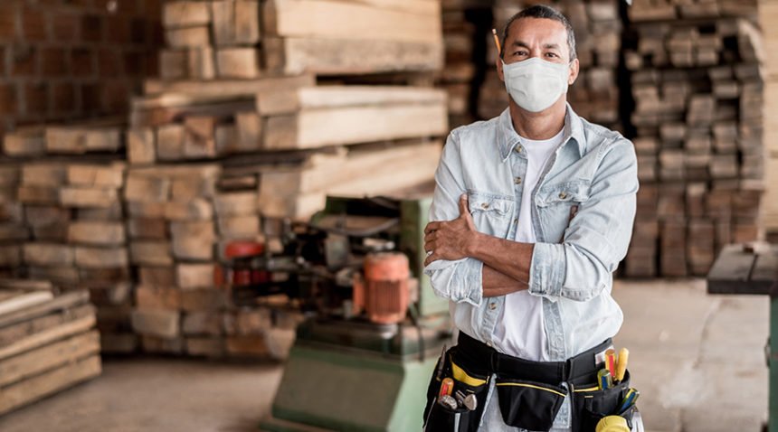 man in construction/lumber warehouse wears face mask