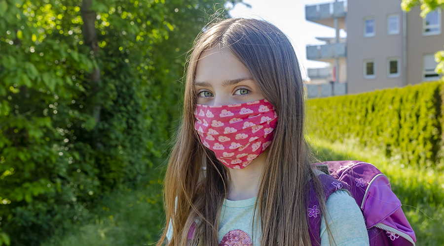 girl wearing face mask looks at camera