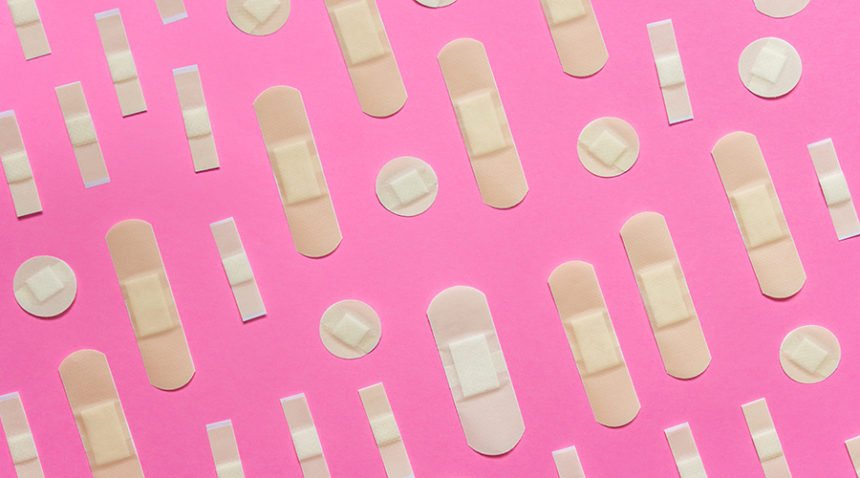 pattern of band aids laid out on pink table