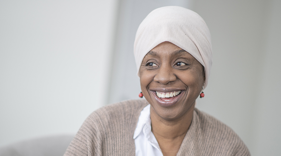 woman wearing head scarf smiles toward camera