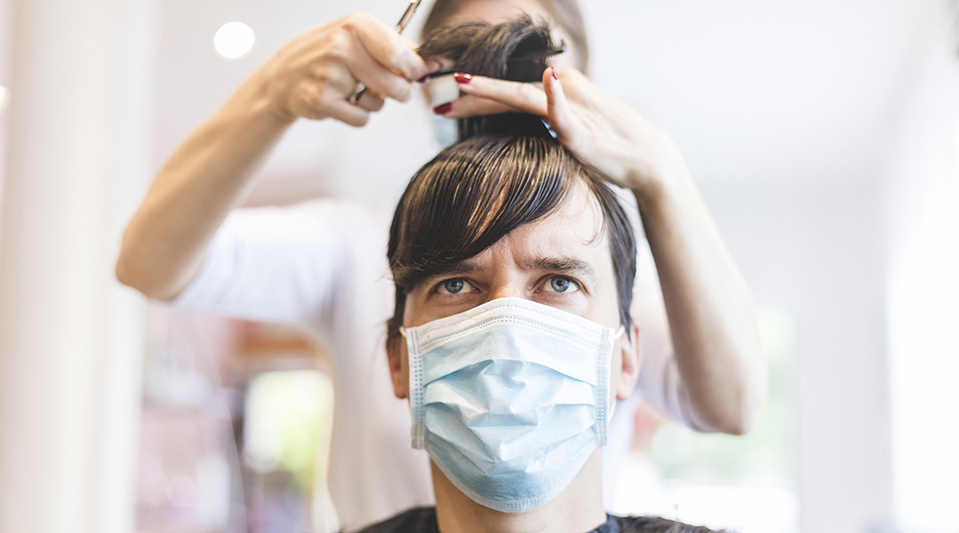 Adult Man Sitting in Hair Salon Wearing Protective Mask During COVID-19 Pandemic.