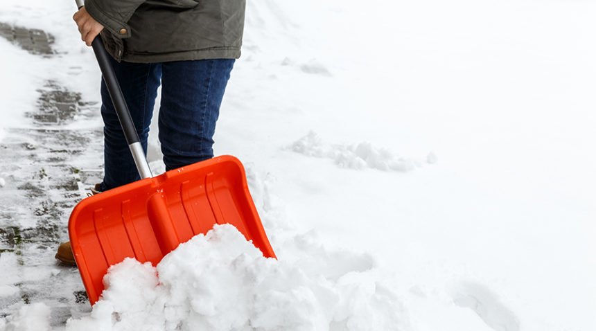 a person shovels a snowy driveway