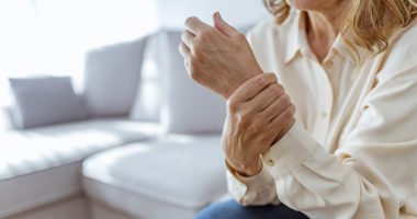 Senior woman rubbing her wrist and arm suffering from rheumatism