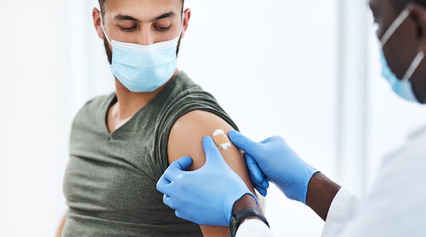 Shot of a doctor applying a band aid after injecting a patient in his arm