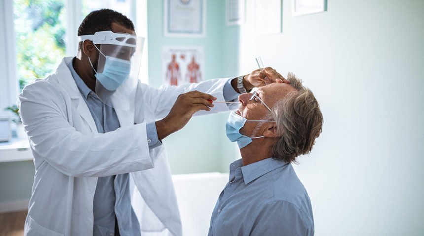 Close up of a mature man having a nasal swab test done by his doctor