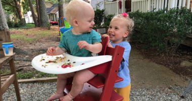 two young siblings smile at each other