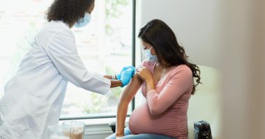 Pregnant woman receives vaccine at doctor's office