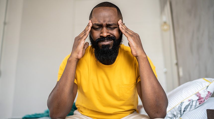 Man waking up with headache at home