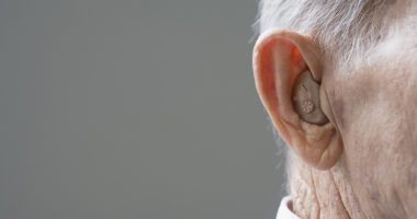 Close up of senior man's hearing aid in ear