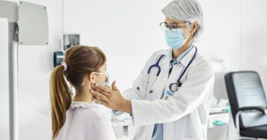 Doctor examines child's throat