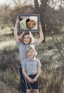 Two brothers holding a picture of their brother