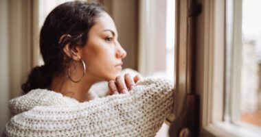 young woman looks contemplatively out of the window