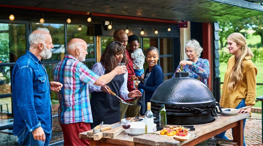 Multi-generational family gathers over an outdoor buffet