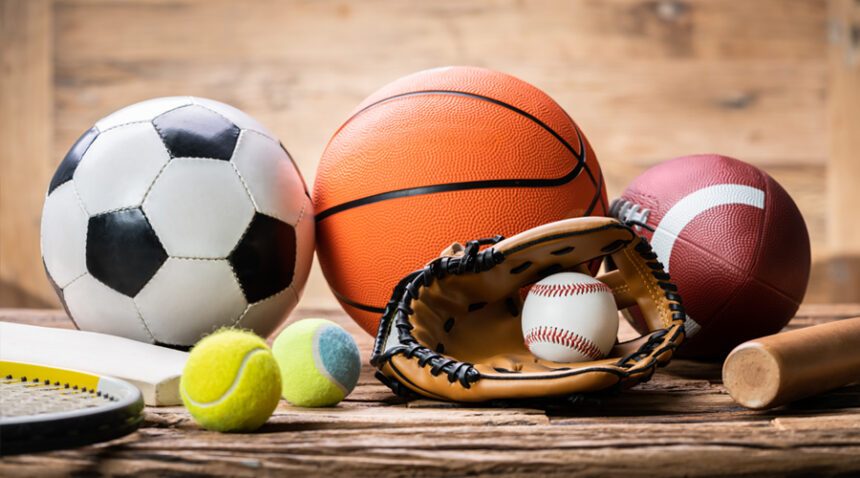 still-life photo of a tennis racquet, tennis ball, soccer ball, basketball, baseball and mitt, football, and baseball bat