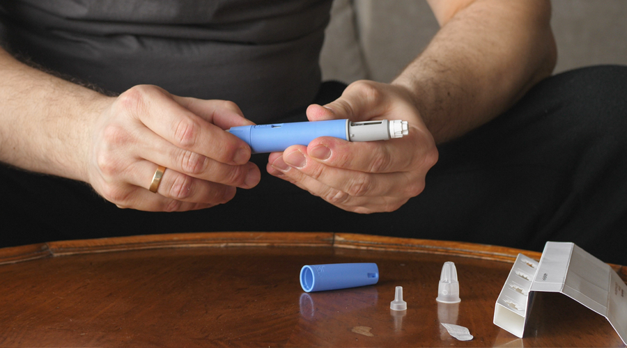 close-up view of man holding a syringe-link medication tube