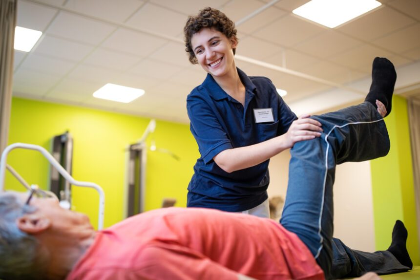Physical therapist helps a patient bend their leg back to improve hip mobility