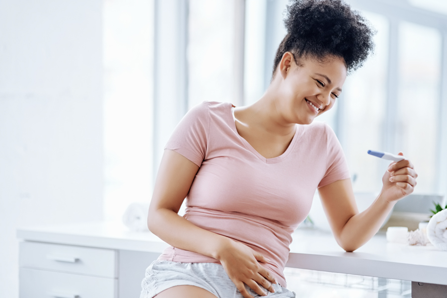 Woman smiling looking at pregnancy test.