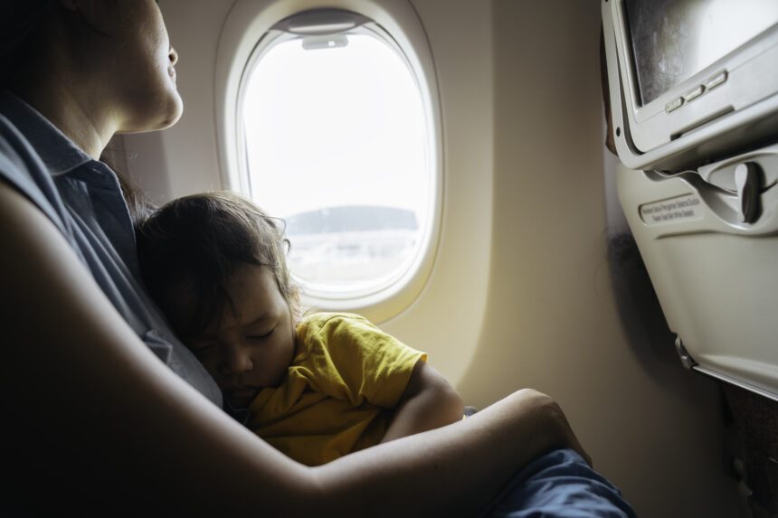 mom holding child on airplane
