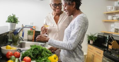 two senior women prepare fresh vegetables in the kitchen