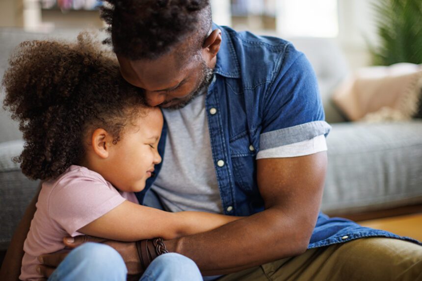 Father and young daughter hug