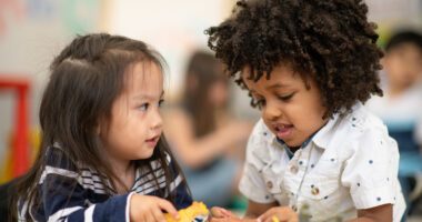 two preschool-age kids playing together at school