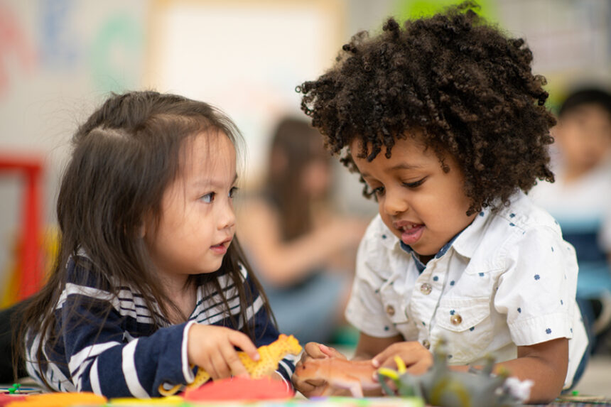 two preschool-age kids playing together at school