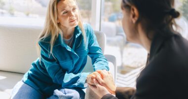 two women learn toward each other in serious conversation