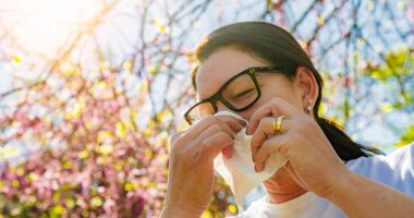 Woman blows nose while she's outside