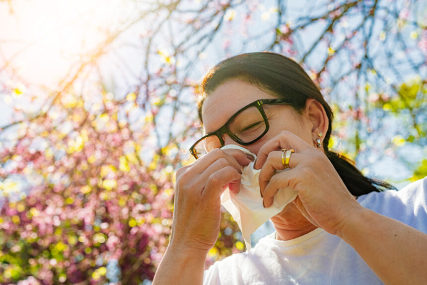 Woman blows nose while she's outside